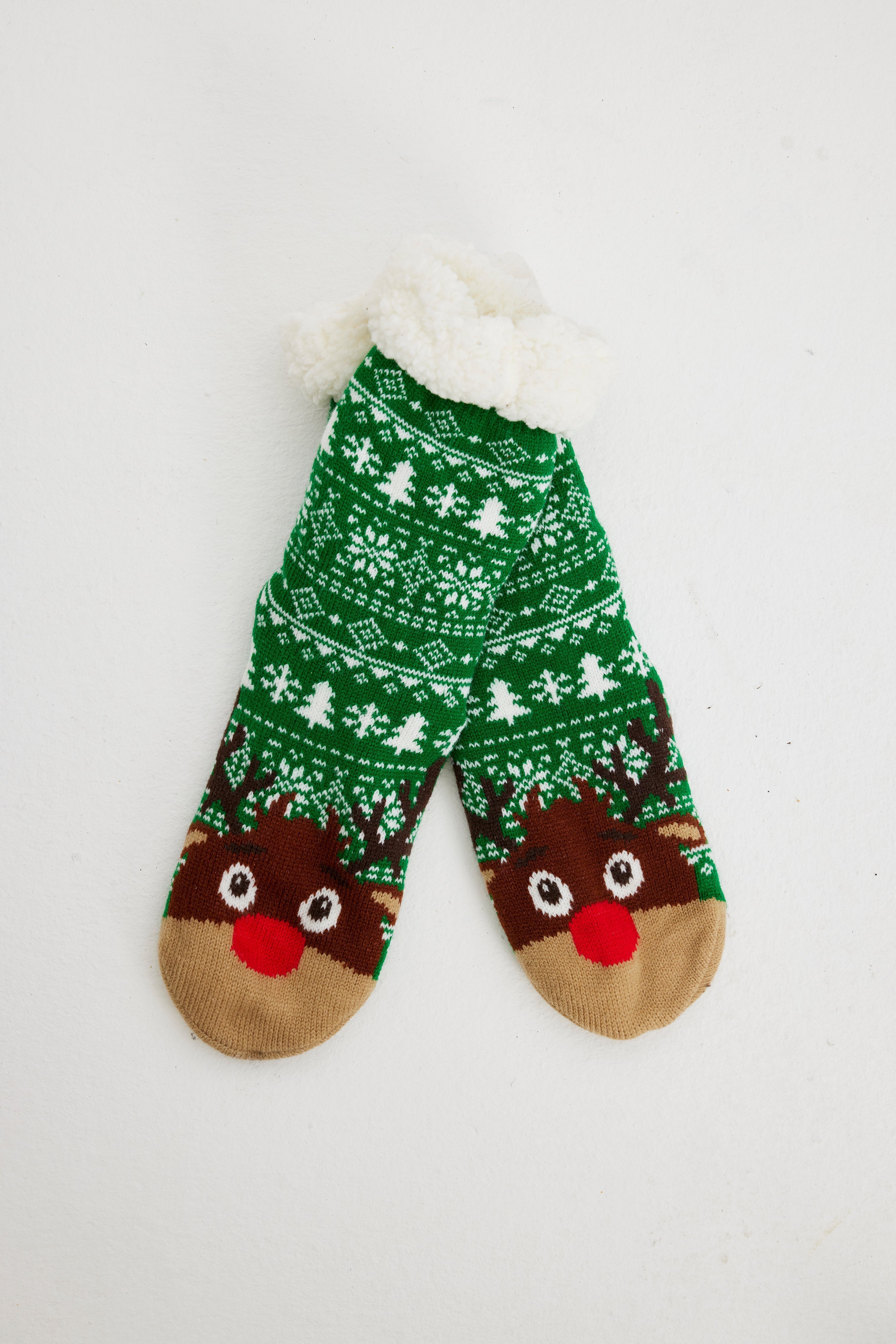 Ein Paar grüne Weihnachtssocken mit einem Rentier darauf.